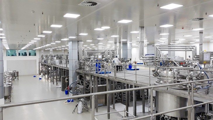 Moderne Produktionshalle mit Edelstahl-Prozessanlagen und Rohrleitungen